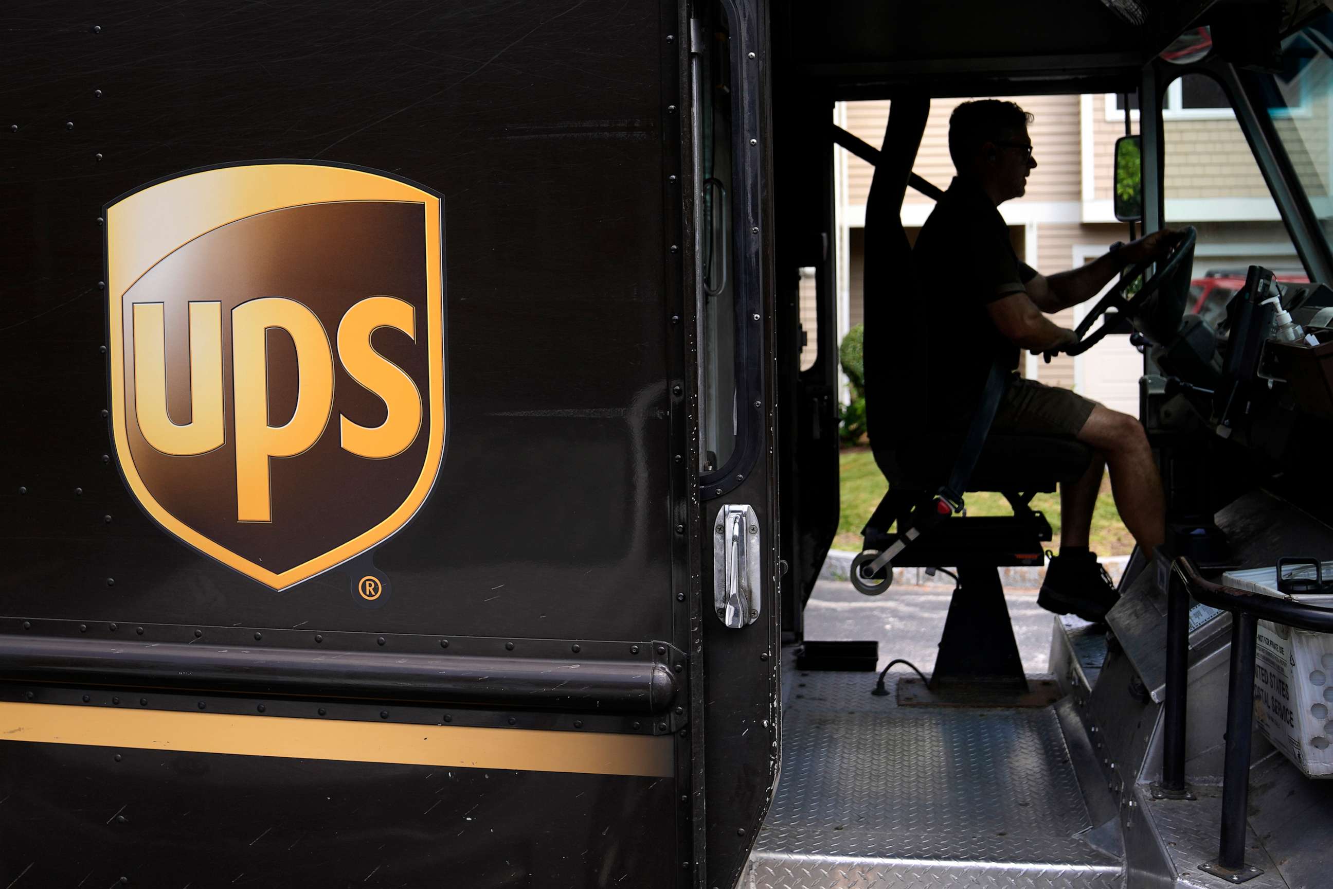 PHOTO: United Parcel Service driver Hudson de Almeida steers through a neighborhood while delivering packages, June 30, 2023, in Haverhill, Mass.