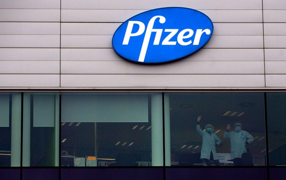 PHOTO: Two workers wave from a window at Pfizer Manufacturing in Puurs, Belgium, Dec. 2, 2020. British officials authorized a COVID-19 vaccine for emergency use, greenlighting the world's first shot against the virus.