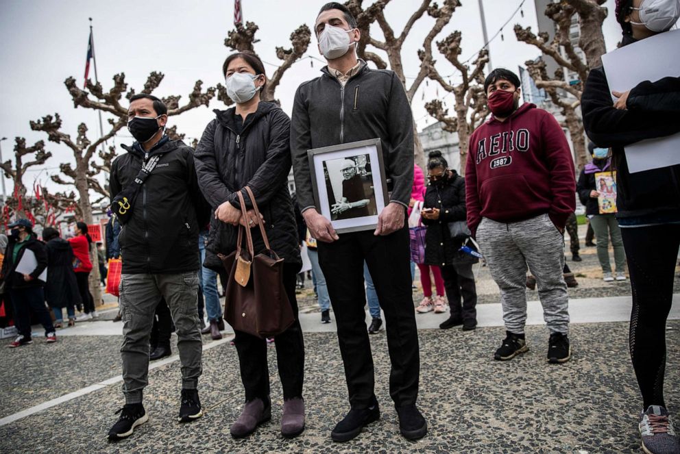 PHOTO: Sanan Wannachit, Monthanus Ratanapakdee, and husband Eric Lawson, who holds a photograph of his late father-in-law Vicha Ratanapakdee, attend a "Love our People: Heal our Communities" rally in San Francisco, Feb. 14, 2021.