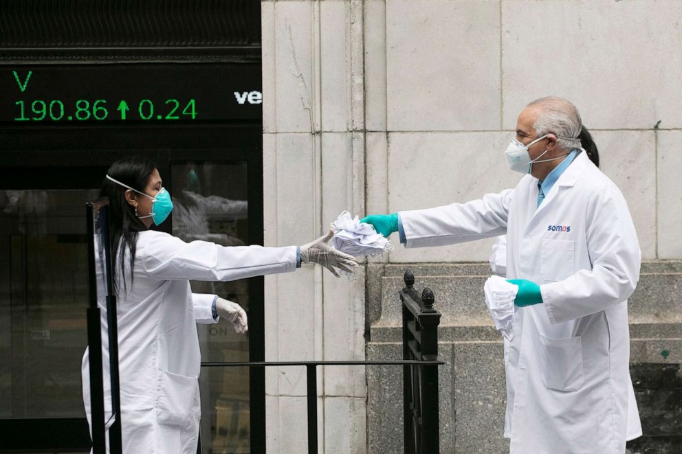 PHOTO: Health care workers prepare to distribute protective face masks to those arriving at the New York Stock Exchange, as the trading floor partially reopens, May 26, 2020.