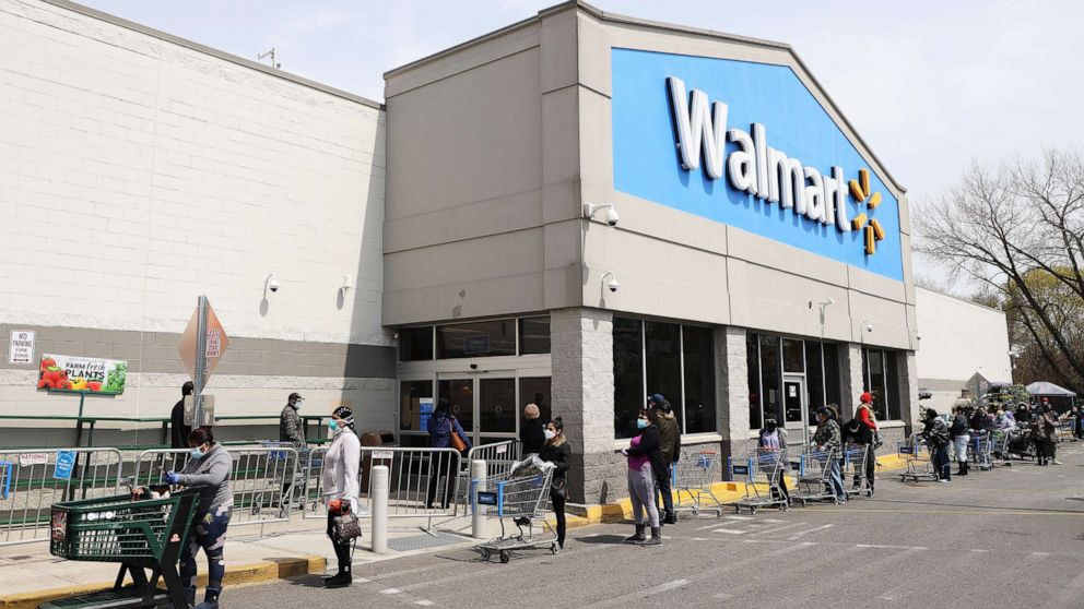 PHOTO: People wearing masks and gloves wait to enter a Walmart on April 17, 2020 in Uniondale, N.Y.