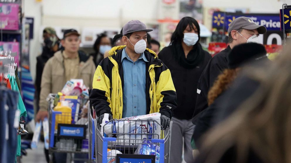 PHOTO: People wearing masks and gloves wait to checkout at Walmart on April 03, 2020 in Uniondale, New York.