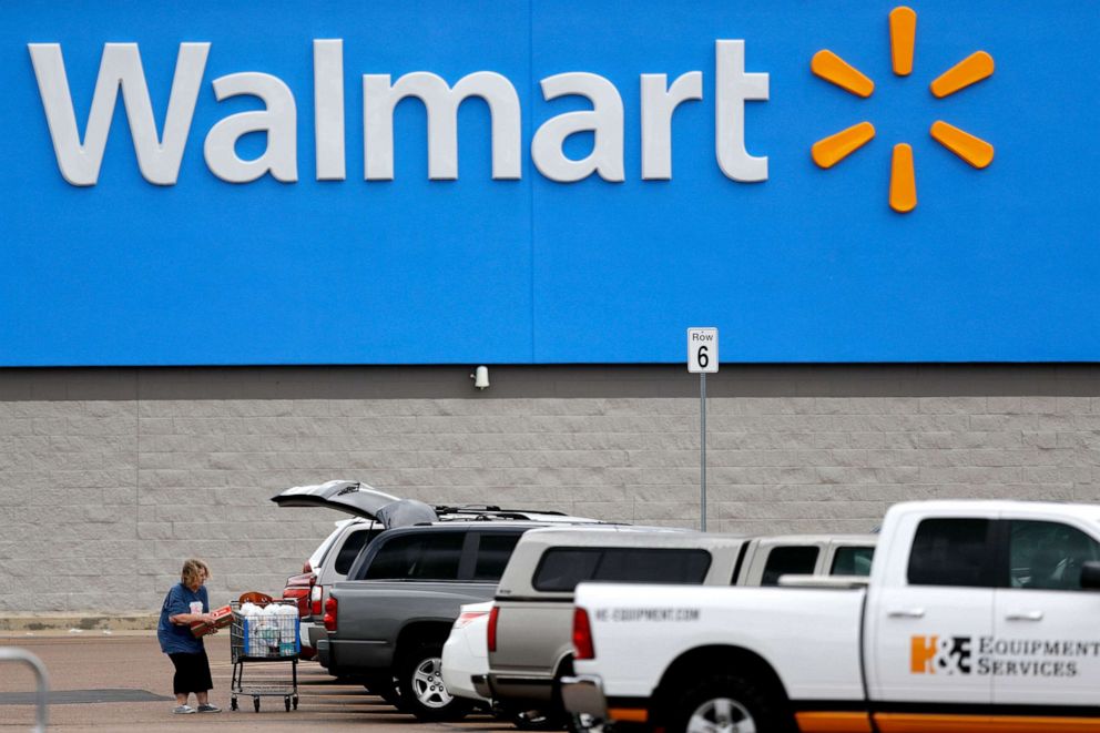 PHOTO: A woman pulls groceries from a cart to her vehicle outside of a Walmart store in Pearl, Miss.