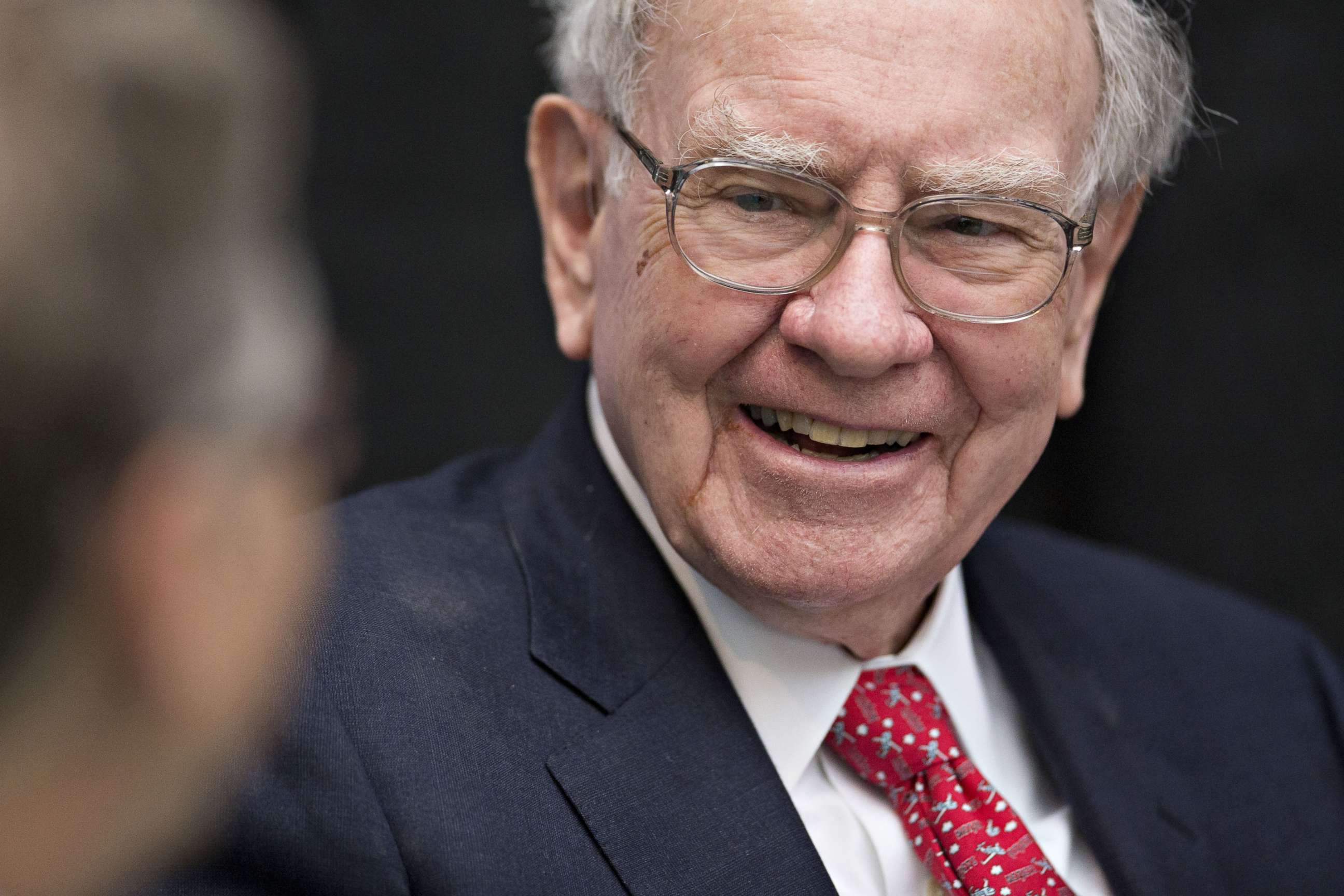 PHOTO: Warren Buffett, chairman and chief executive officer of Berkshire Hathaway Inc., laughs while playing cards on the sidelines the Berkshire Hathaway annual shareholders meeting in Omaha, Neb., May 1, 2016.