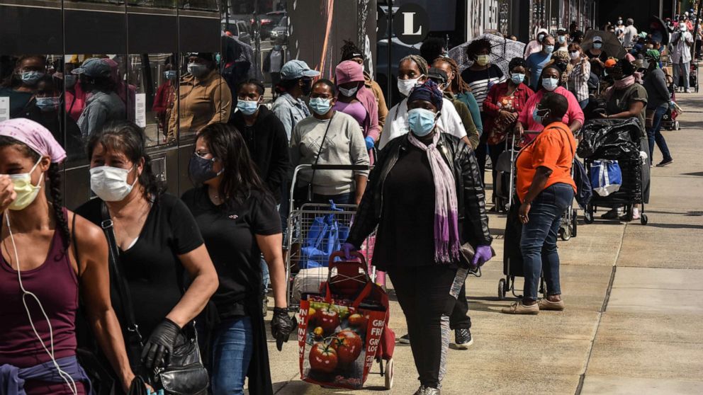 PHOTO: People wait on a long line to receive a food bank donation at the Barclays Center on May 15, 2020 in the Brooklyn borough in New York City.