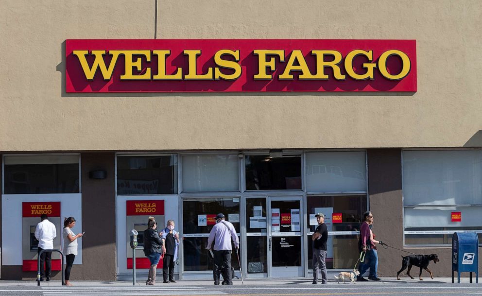 PHOTO: In this April 3 2020 file photo, customers, some wearing face masks, line up outside a Wells Fargo branch in the Atwater Village neighborhood of Los Angeles during the coronavirus outbreak. 