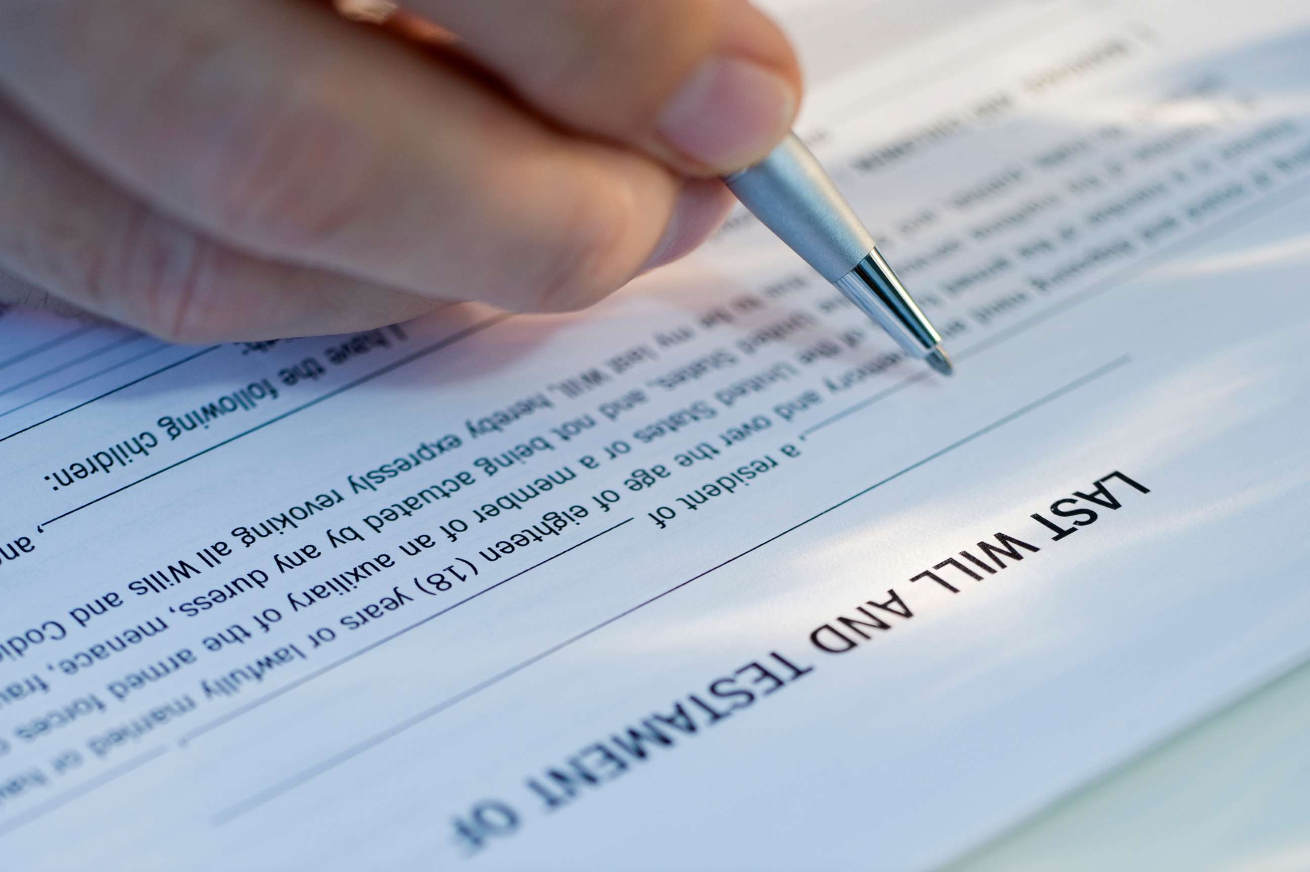 PHOTO: A person fills out a document to create a will.