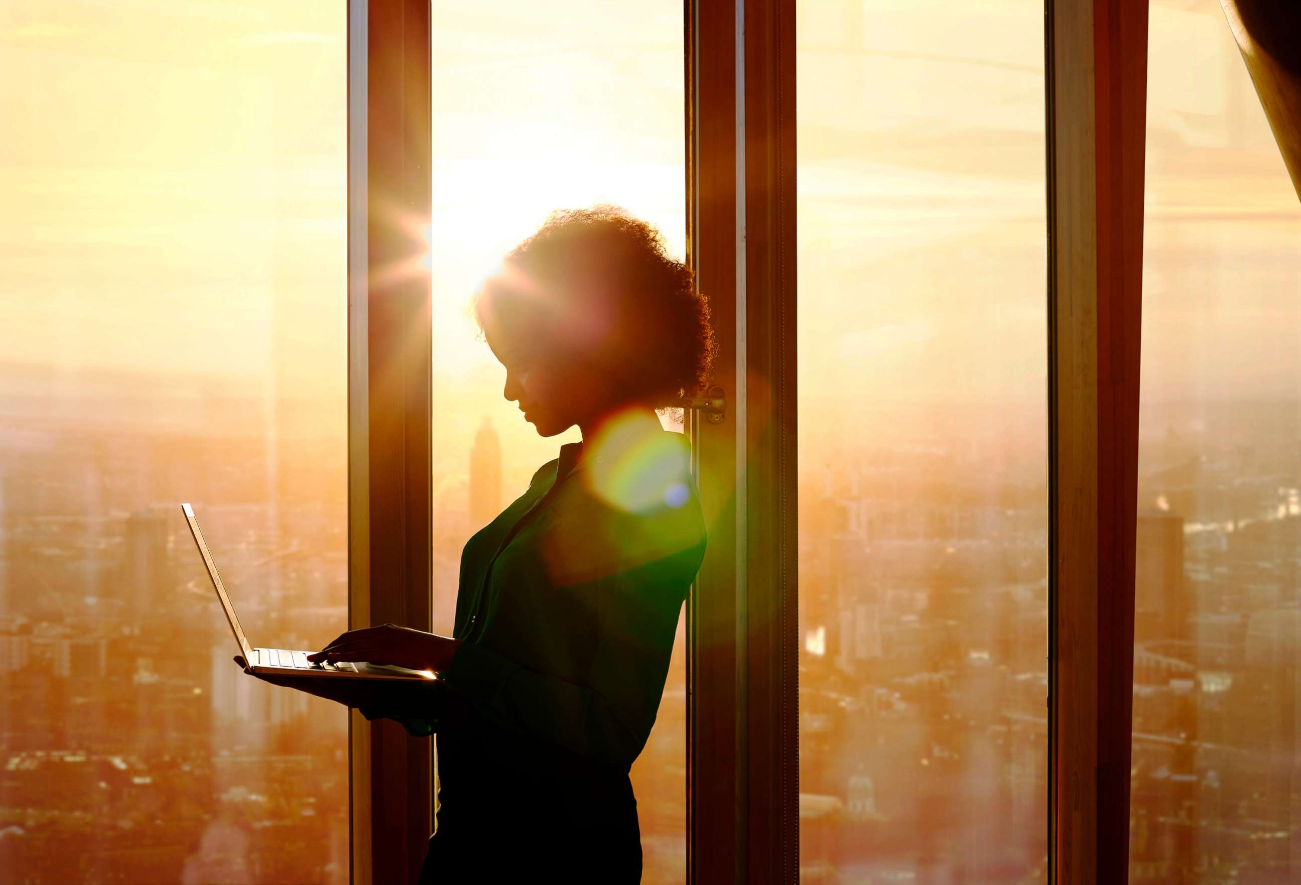 PHOTO: A woman poses holding a laptop computer in a corporate business settting in an undated stock image.