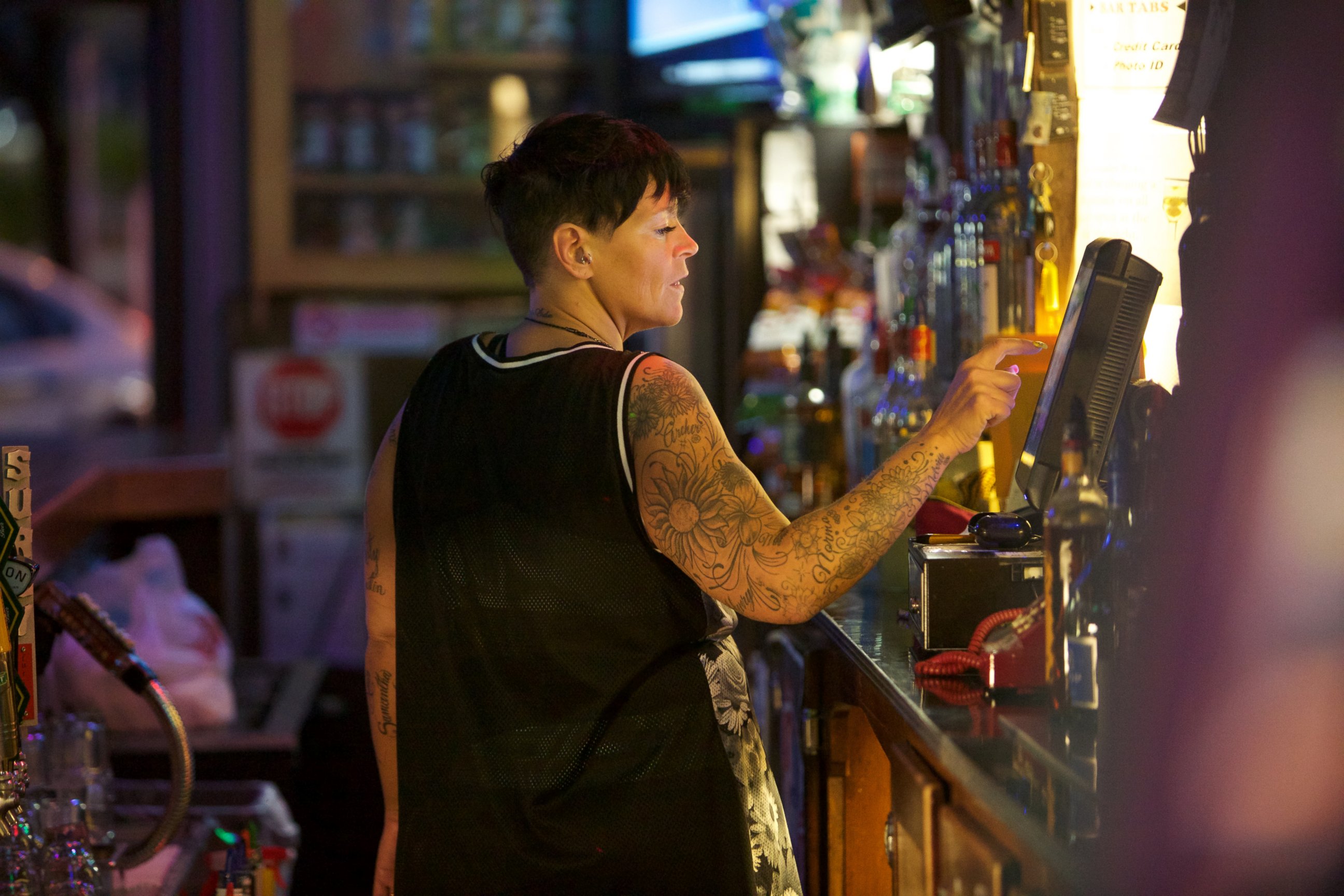 PHOTO: Bartender Kimberly Ruzynski worked the register after serving patrons that turned out to sing Karaoke to honor Prince, April 21, 2016. 