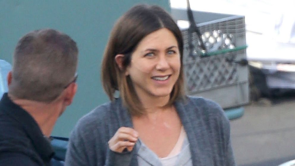 Jennifer Aniston has a few laughs with one of the crew members on the set of her new movie "Cake".  
