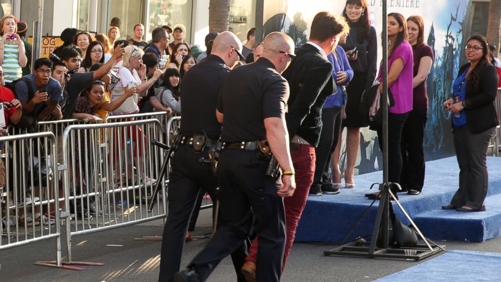 A man identified as Vitalii Sediuk, 25, is walked off the red carpet in handcuffs after approaching Brad Pitt at the world premiere of "Maleficent" at the El Capitan Theatre, May 28, 2014, in Los Angeles.