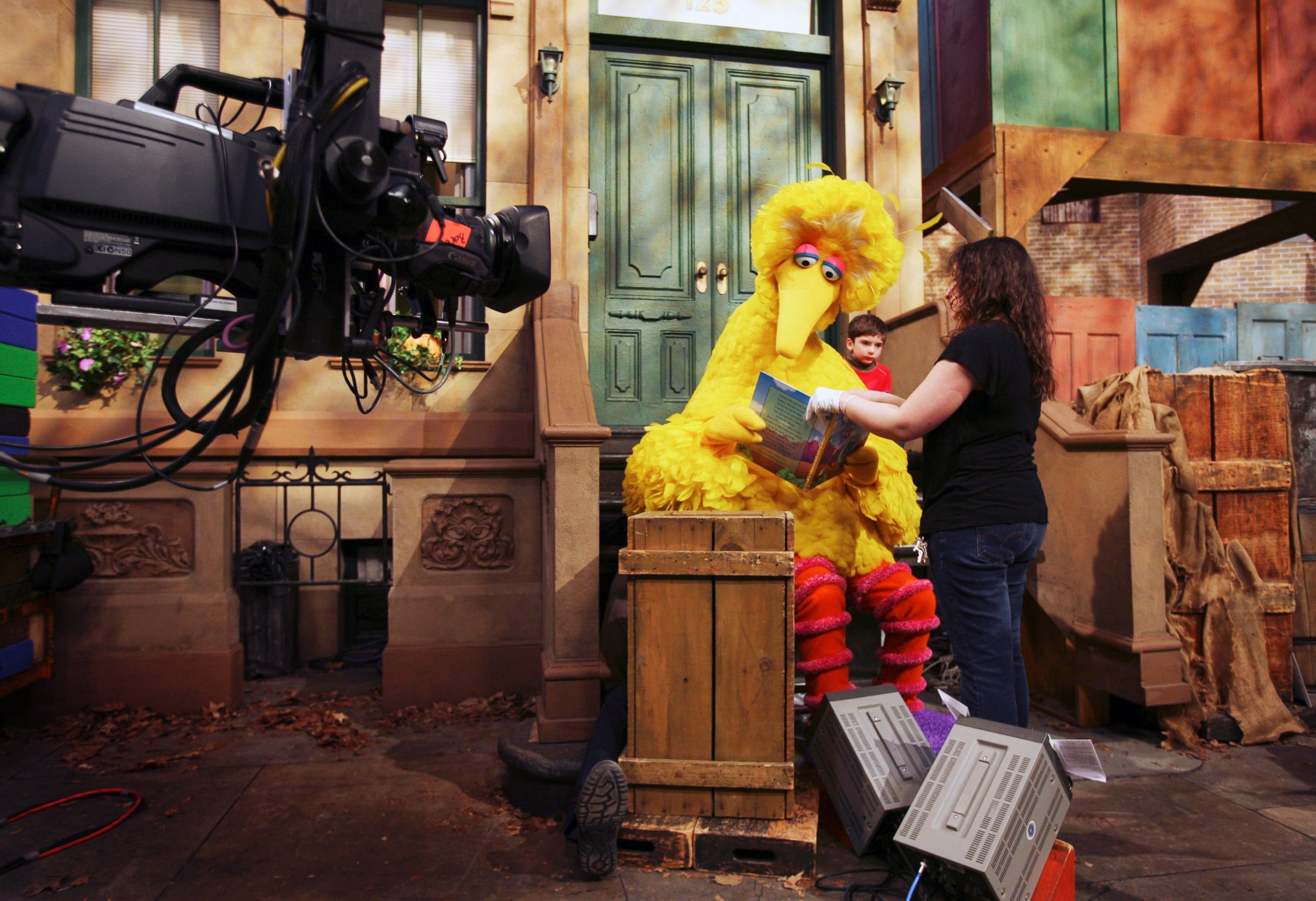 PHOTO: Michelle Hickey, a Muppet wrangler adjusts a book for Big Bird, voiced by Carroll Spinney, so he can read to Connor Scott during a taping of Sesame Street in New York, April 10, 2008.