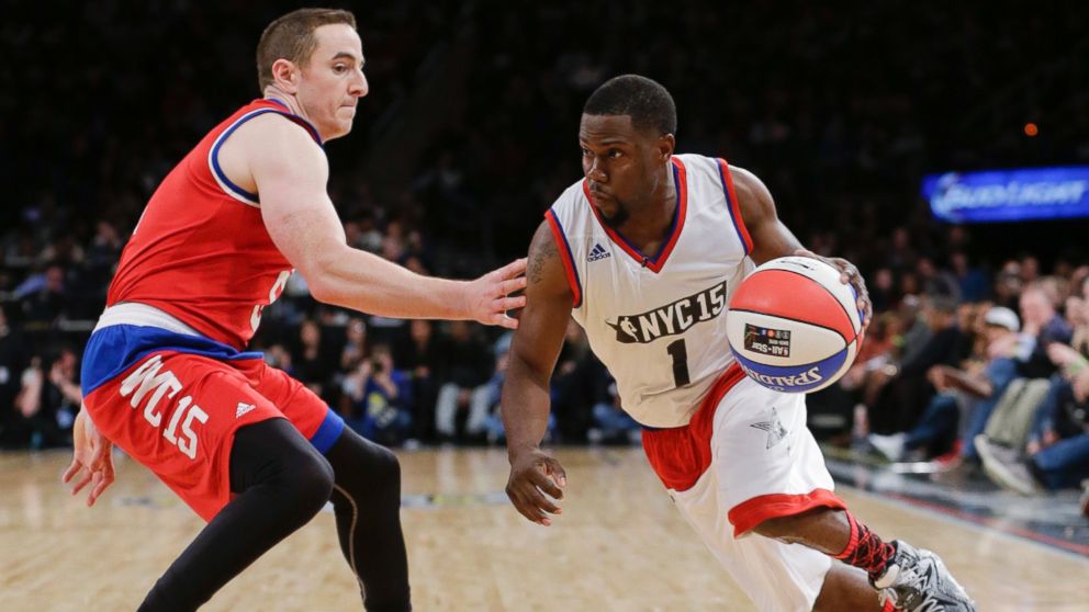 Kevin Hart, right, drives past Robert Pera, left, during the second half of the NBA All-Star celebrity basketball game Friday, Feb. 13, 2015, in New York. 