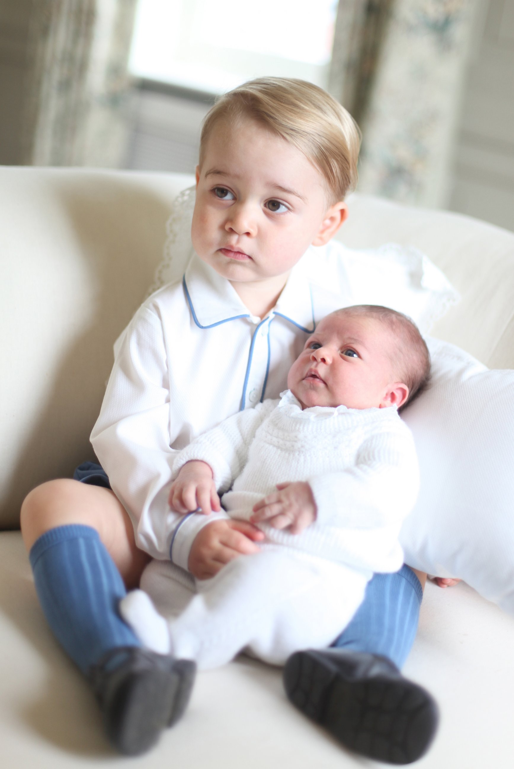 PHOTO: Britain's Princess Charlotte, right, being held by her brother, 2-year-old, Prince George.