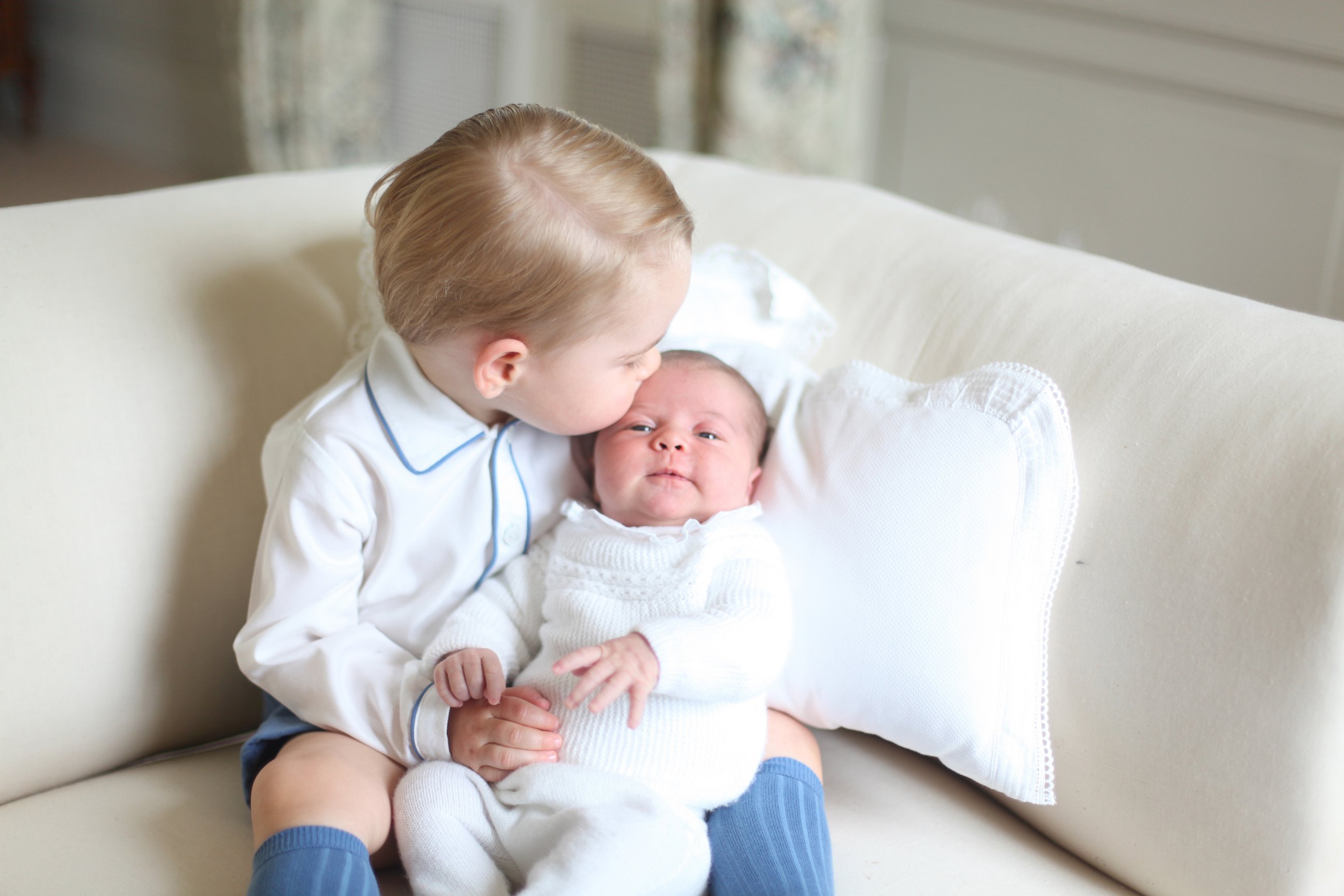 PHOTO: Britain's Princess Charlotte, right, being held by her brother, 2-year-old, Prince George.