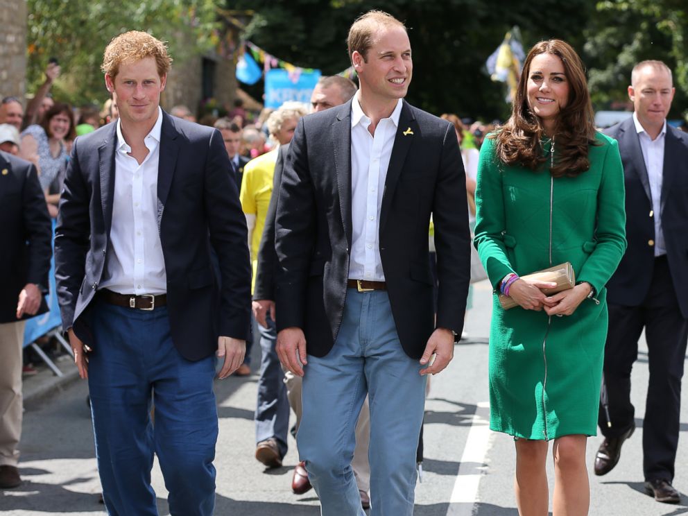 PHOTO: (L-R) Prince Harry, Prince William and Kate, Duchess of Cambridge walk along the street to celebrate the start of the Tour de France in Yorkshire at West Tanfield, England, Saturday, July 5, 2014.