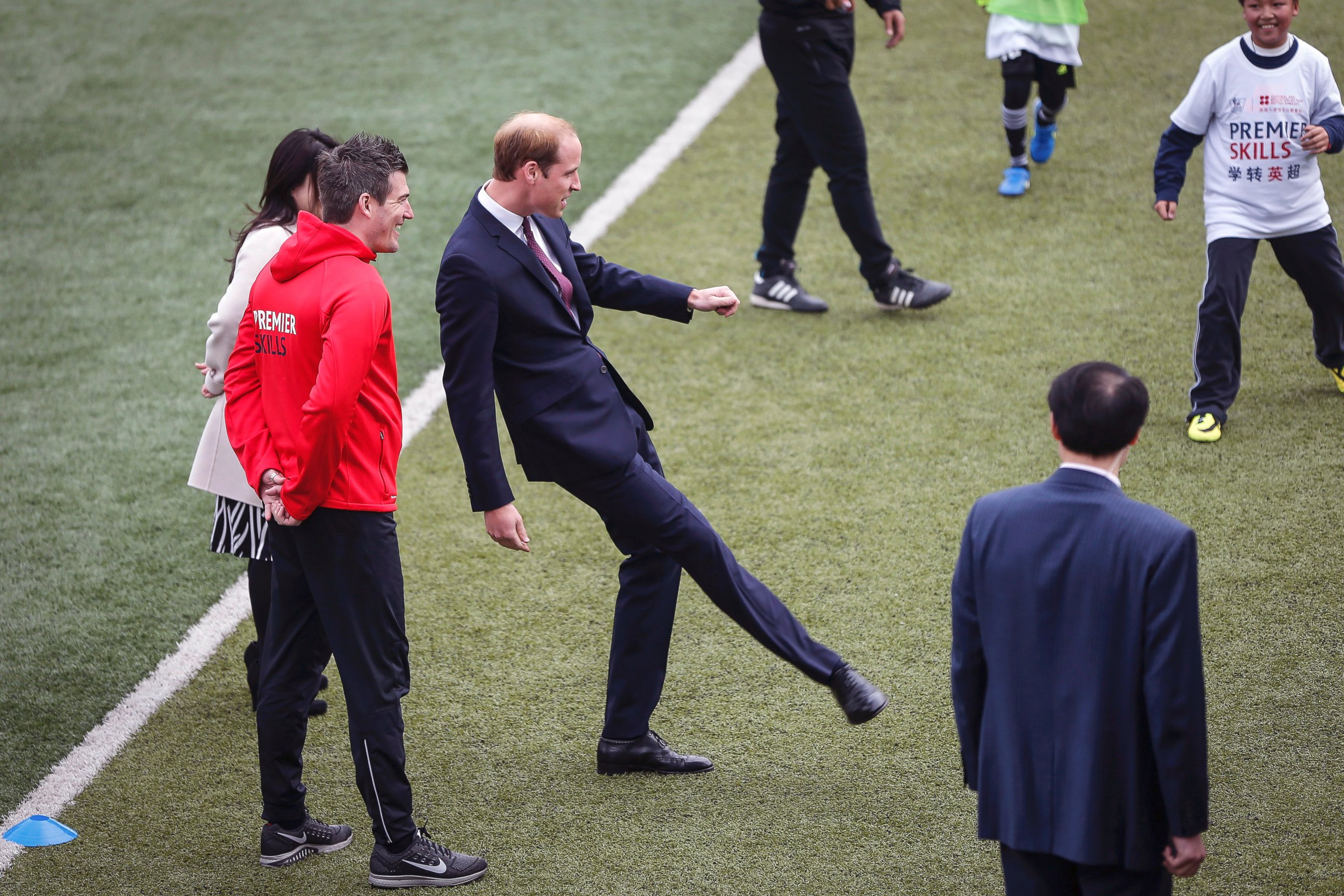 PHOTO: Britain's Prince William, center, kicks a ball as he attends the Premier Skills football coaching event at Nanyang Secondary School in Shanghai, March 3, 2015.