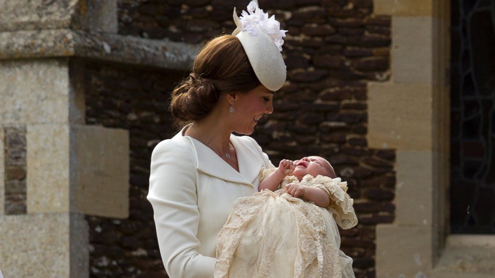 Britain's Kate the Duchess of Cambridge carries Princess Charlotte after taking her out of a pram as they arrive for Charlotte's Christening at St. Mary Magdalene Church in Sandringham, England, July 5, 2015. 