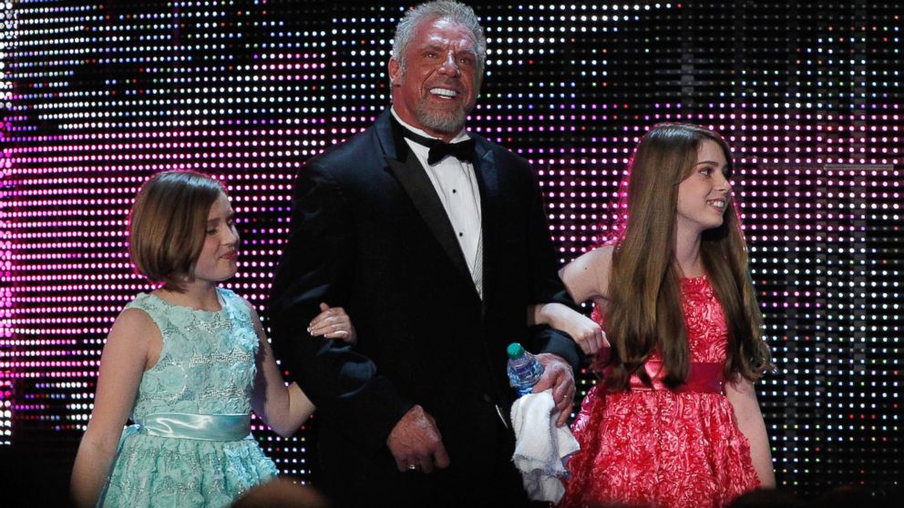 James Hellwig, aka The Ultimate Warrior, is escorted by his daughters to the stage during the WWE Hall of Fame Induction at the Smoothie King Center in New Orleans, April 5, 2014. 