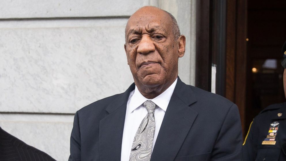 Actor and comedian Bill Cosby looks on as his publicist Andrew Wyatt addresses the media outside the Montgomery County Courthouse, June 17, 2017, in Norristown, Penn. After 52 hours of deliberation, a mistrial was announced in Cosby's sexual assault trial. 