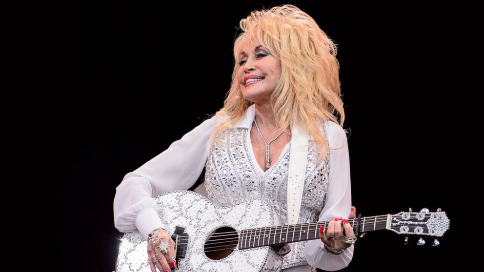 This file photo taken on June 29, 2014 shows U.S. country music singer Dolly Parton  on the Pyramid Stage, on the final day of the Glastonbury Festival of Music and Performing Arts on Worthy Farm in Somerset, southwest England. Parton released a public service announcement on Nov. 27, 2016 urging visitors and residents of the region to exercise caution when handling fire, even as the blaze was nearing her iconic theme park. 