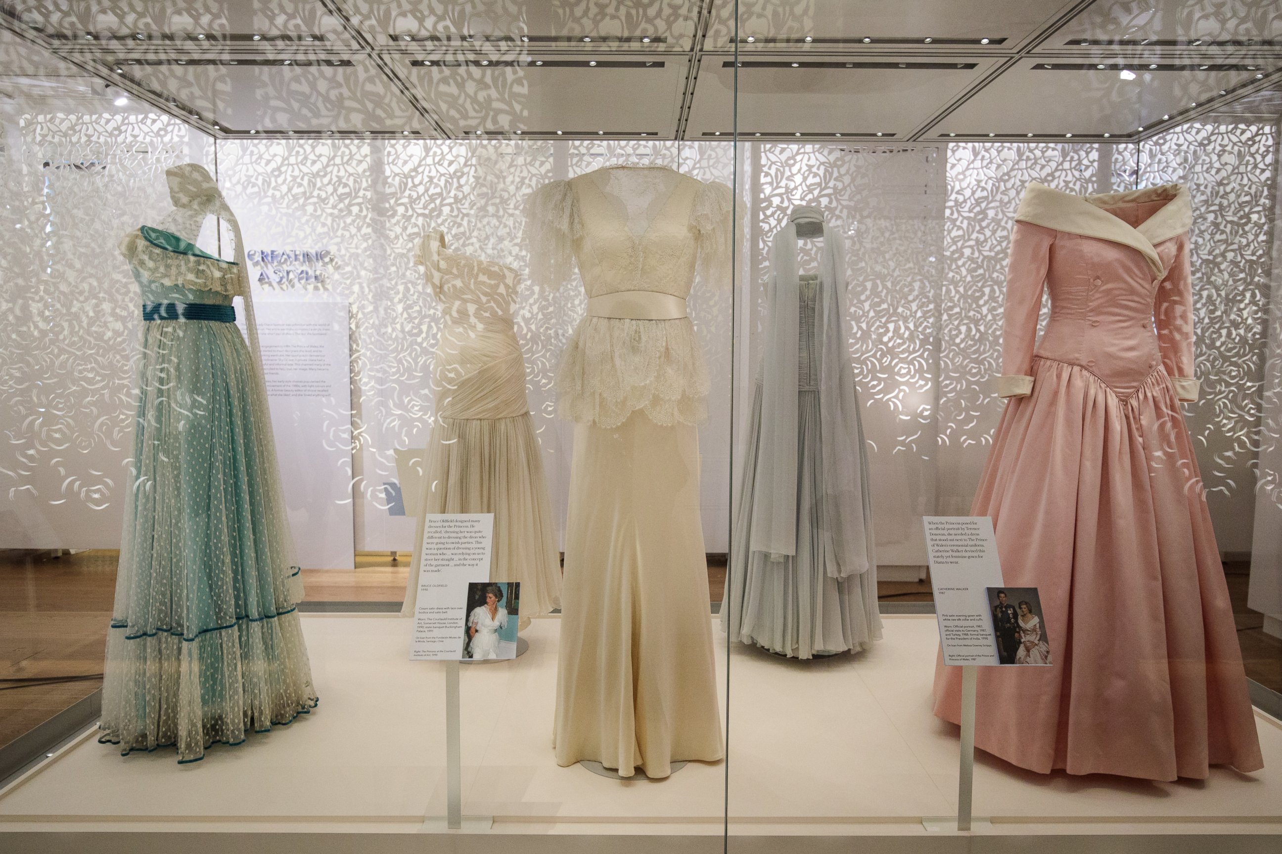 PHOTO: A 1990 Bruce Oldfield cream satin dress and a 1987 Catherine Walker pink satin evening gown (R) worn by princess Diana for an official portrait in 1987 at a press preview at Kensington Palace, on Feb. 22, 2017 in London.