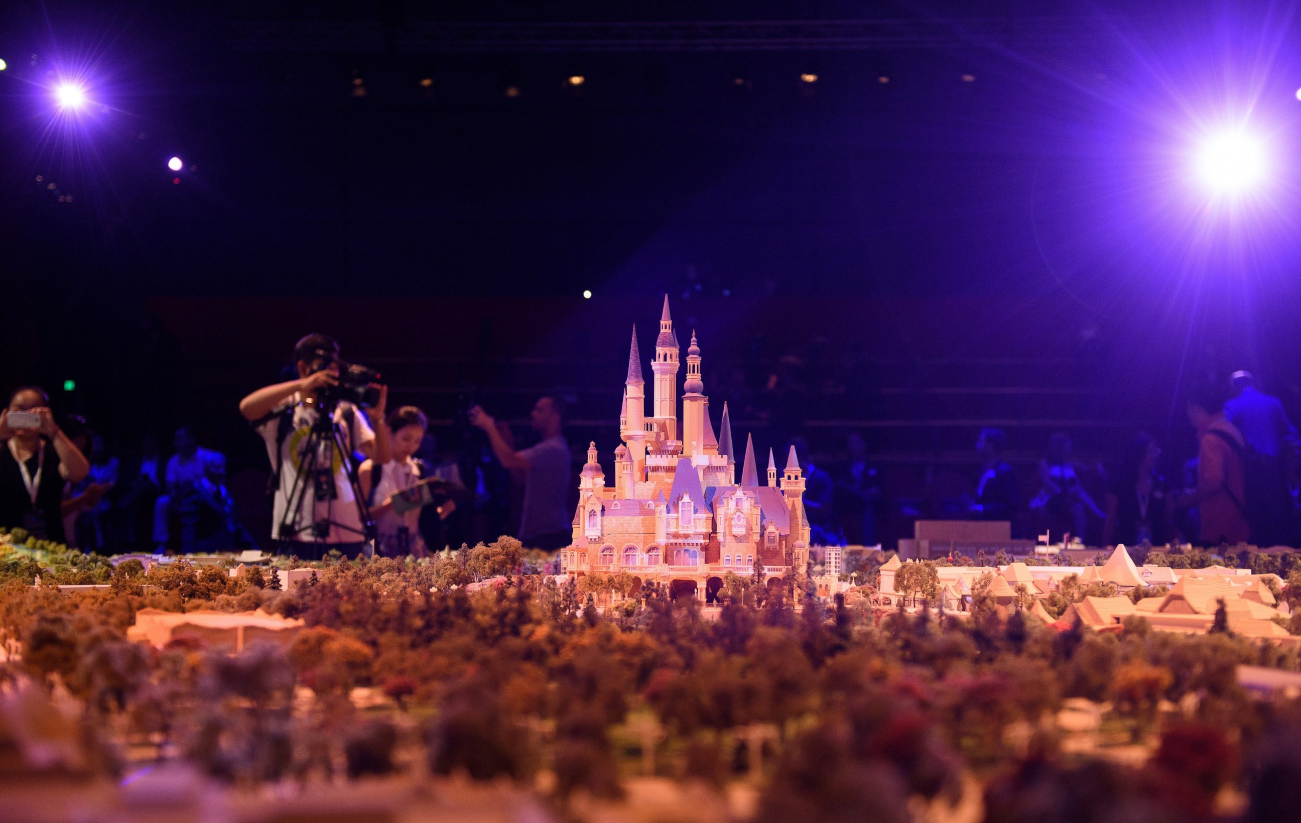 PHOTO: Members of the media take images of a model of the Shanghai Disney Resort during a press event in Shanghai, July 15, 2015.
