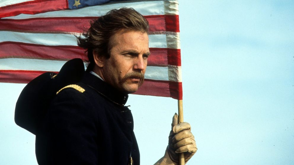 PHOTO: Kevin Costner holding an American flag in a scene from the film "Dances With Wolves", 1990.