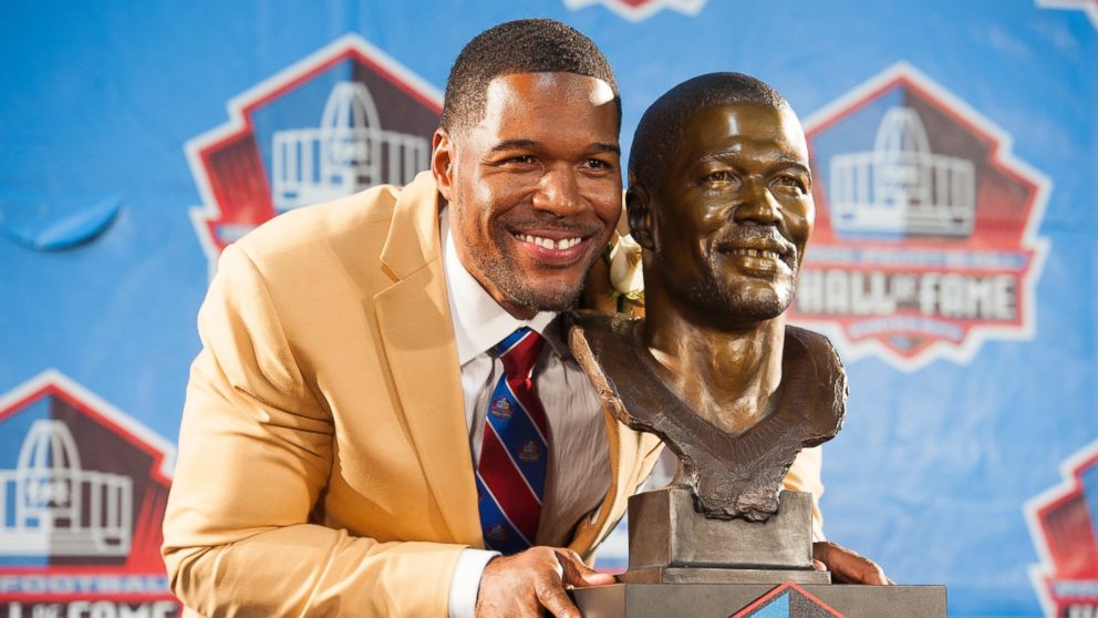 Michael Strahan, former New York Giants defensive end, with his bust during the NFL Class of 2014 Pro Football Hall of Fame Enshrinement Ceremony at Fawcett Stadium in Canton, Ohio, August 2, 2014.