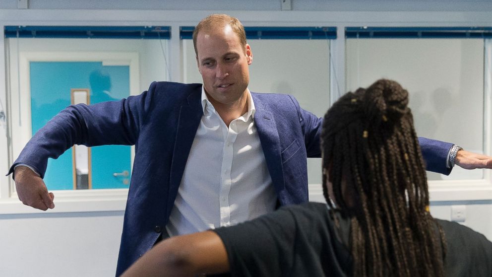 Britain's Prince William, Duke of Cambridge, learns a dance move with Scariofunk dance collective during a visit to Caius House Youth Centre in London on September 14, 2016. 
