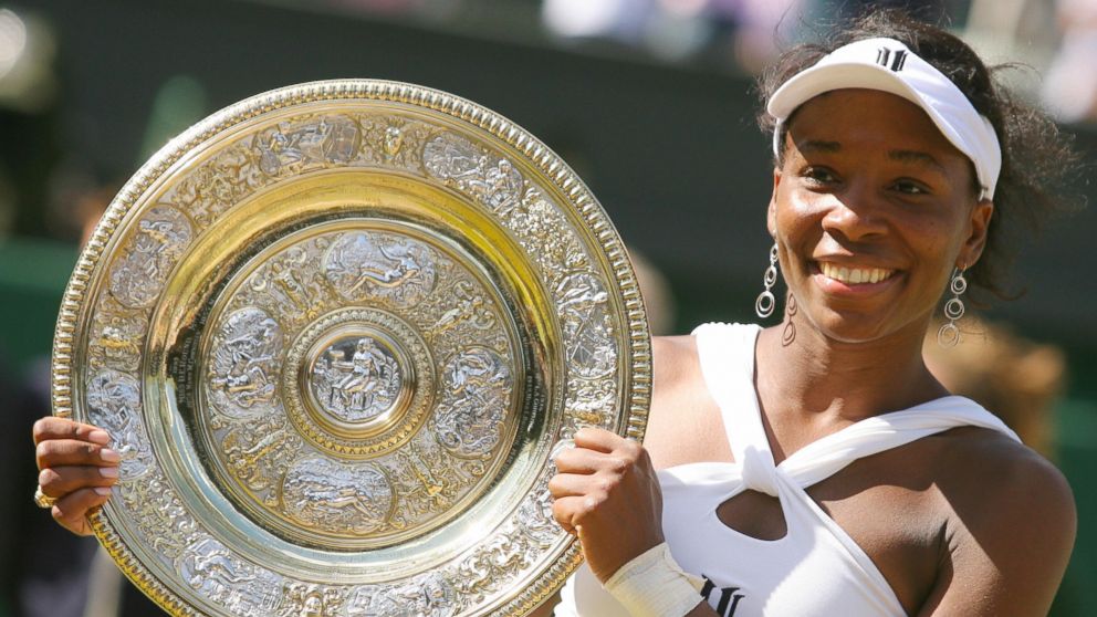 US Venus Williams poses holding her trophy after beating her sister Serena during their final tennis match of the 2008 Wimbledon championships at The All England Tennis Club in southwest London, July 5, 2008. Venus Williams won 7-5, 6-4. 