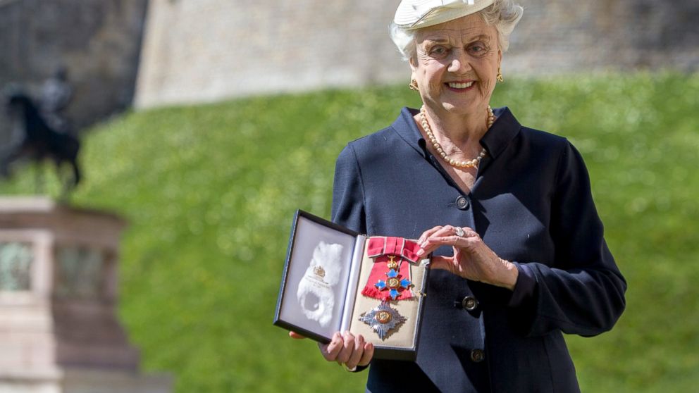 PHOTO: Angela Lansbury poses with her Dame Commander (DBE) medal given to her by Queen Elizabeth II at an Investiture ceremony at Windsor Castle,  April 15, 2014 in Berkshire, England.