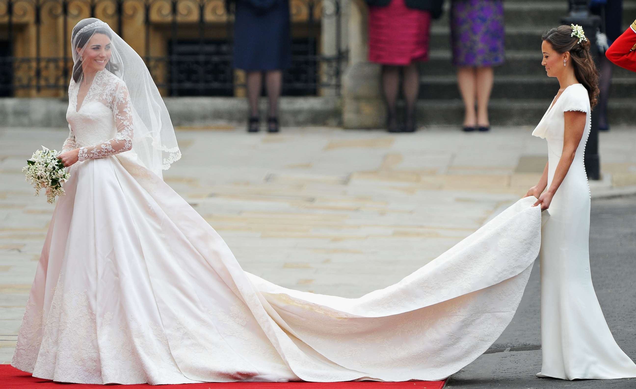 PHOTO: Catherine Middleton waves to the crowds as her sister and Maid of Honor Pippa Middleton holds her dress before walking in to the Abbey to attend the Royal Wedding of Prince William to Catherine Middleton at Westminster Abbey on April 29, 2011.