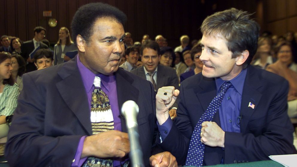 Boxing legend Muhammad Ali (L) and actor Michael J. Fox (R) talk before the start of a Senate subcommittee on Labor, Health, Human Services and Education hearing on Parkinson's Disease, May 22, 2002 on Capitol Hill in Washington.