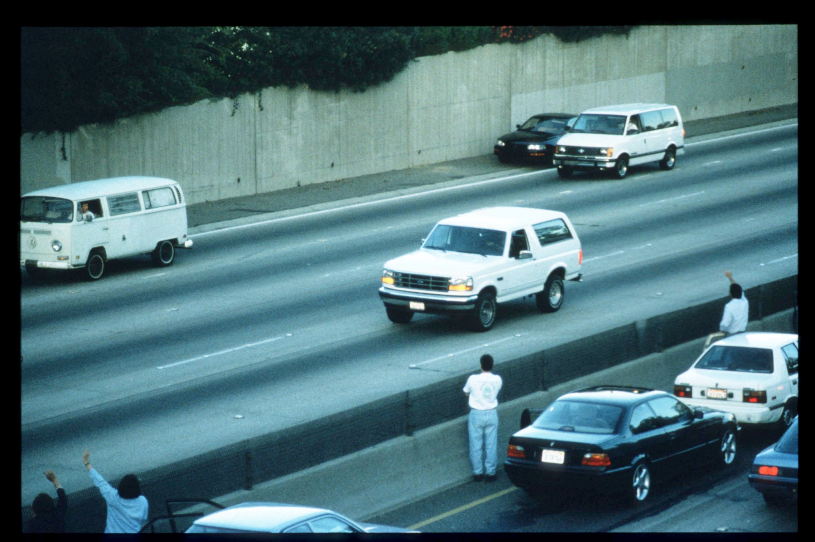 PHOTO: Motorists wave as police cars pursue the white Ford Bronco, center, driven by Al Cowlings, carrying fugitive murder suspect O.J. Simpson, June 17, 1994, on the 405 freeway in Los Angeles.