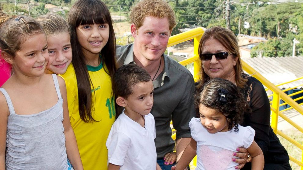 Prince Harry poses with local children from a village during a trip to the Atlantic Rainforest near Sao Paulo, Brazil, June 25, 2014. 