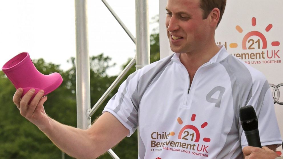 Prince William, Duke of Cambridge, receives a gift for his new daughter Princess Charlotte of Cambridge during day two of the Audi Polo Challenge at Coworth Park, May 31, 2015, in London.