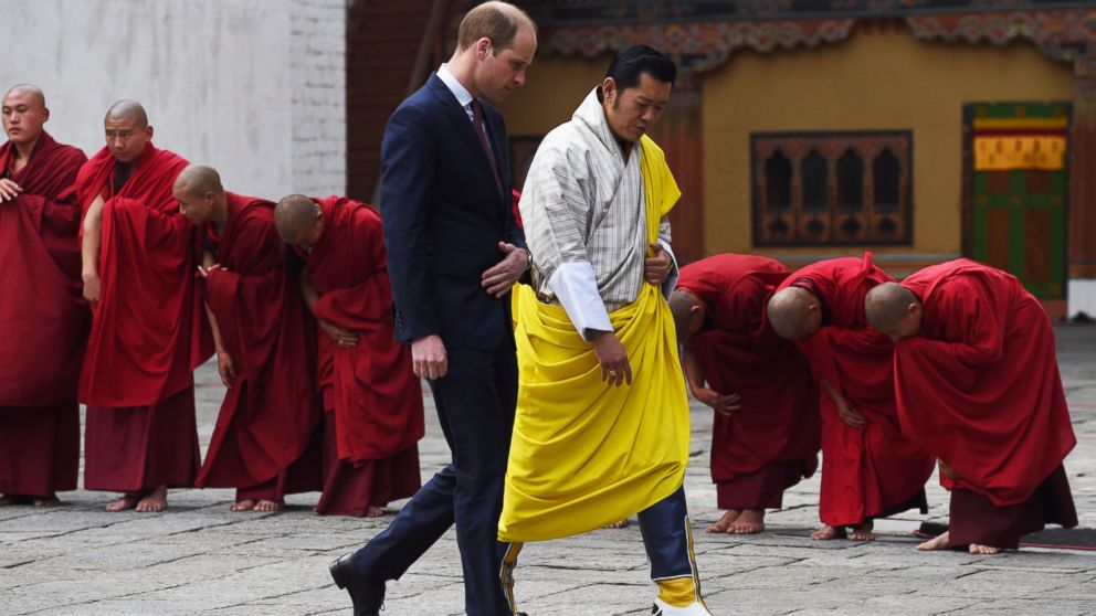PHOTO:Prince William, Duke of Cambridge walks with King Jigme Khesar Namgyel Wangchuck past a row of bowing Buddhist monks as they leave a Buddhist temple at the Tashicho Dzong in Thimphu, April 14, 2016. 