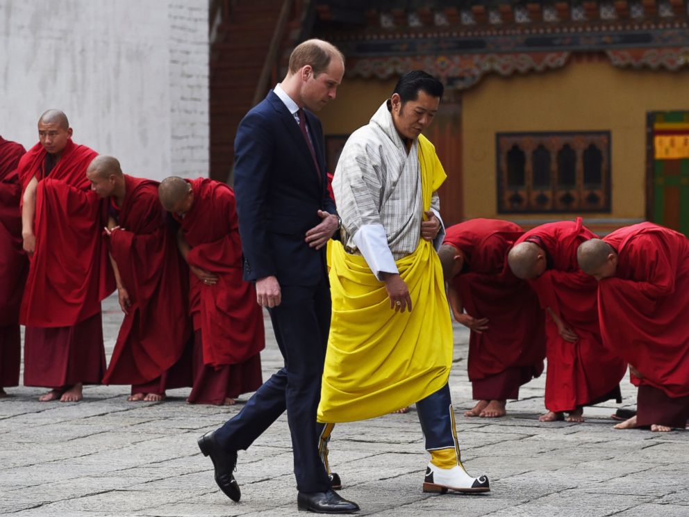 PHOTO:Prince William, Duke of Cambridge walks with King Jigme Khesar Namgyel Wangchuck past a row of bowing Buddhist monks as they leave a Buddhist temple at the Tashicho Dzong in Thimphu, April 14, 2016.