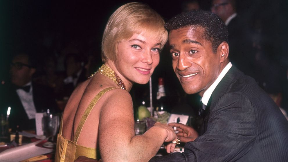 May Britt and Sammy Davis Jr. pose for a photo at a formal dinner, circa 1965.