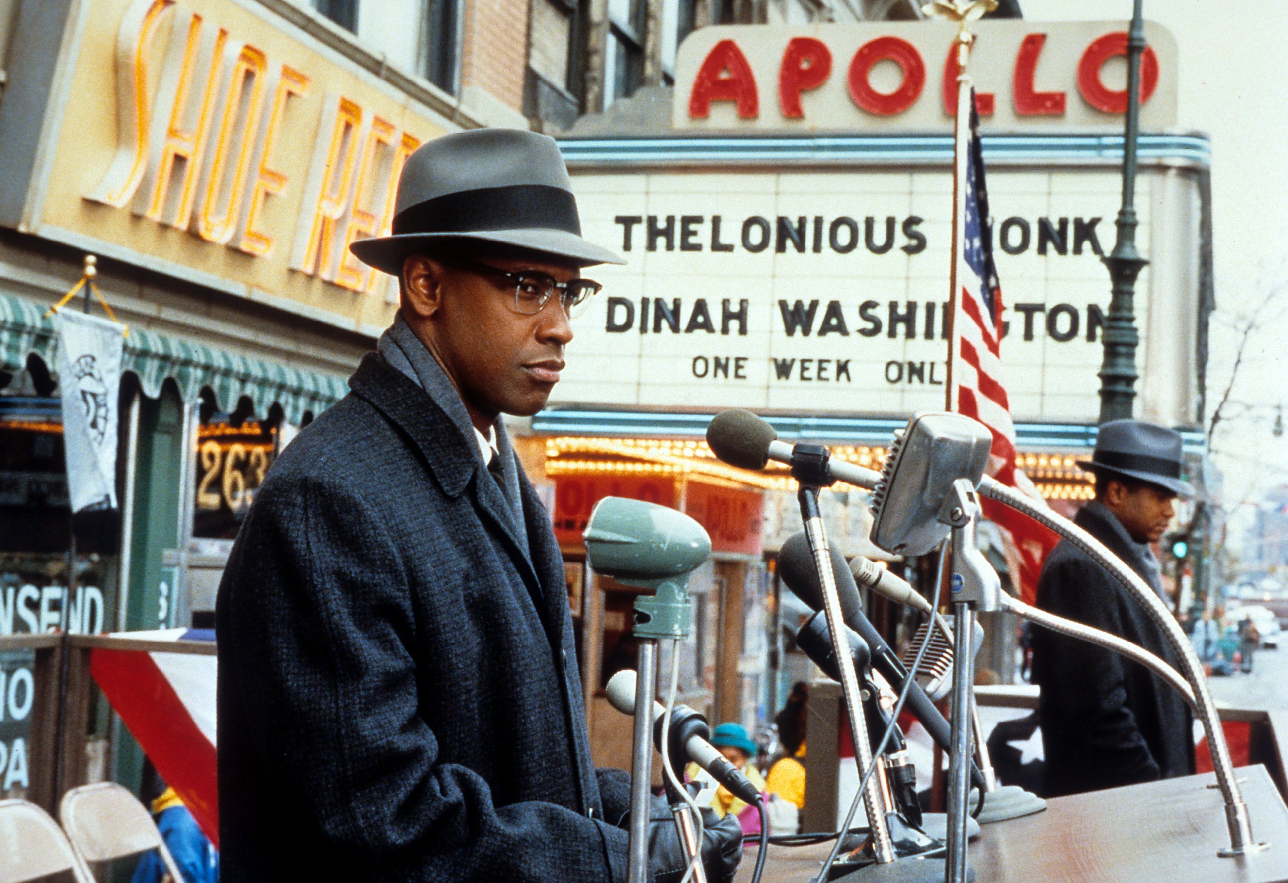 PHOTO: Denzel Washington standing behind microphones in a scene from the film 'Malcom X', 1992. 