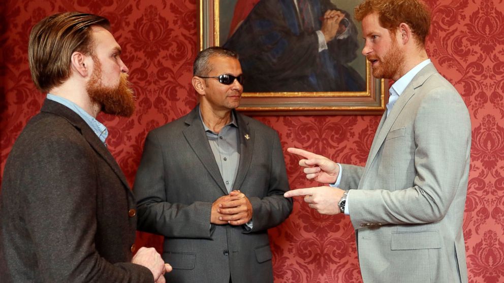 PHOTO: Britain's Prince Harry speaks with U.S. Armed Forces veteran Ivan Castro, center, and British Armed Forces veteran Karl Hinett, who will run the Boston and London Marathons for the Heads Together Campaign in London, March 16, 2017.