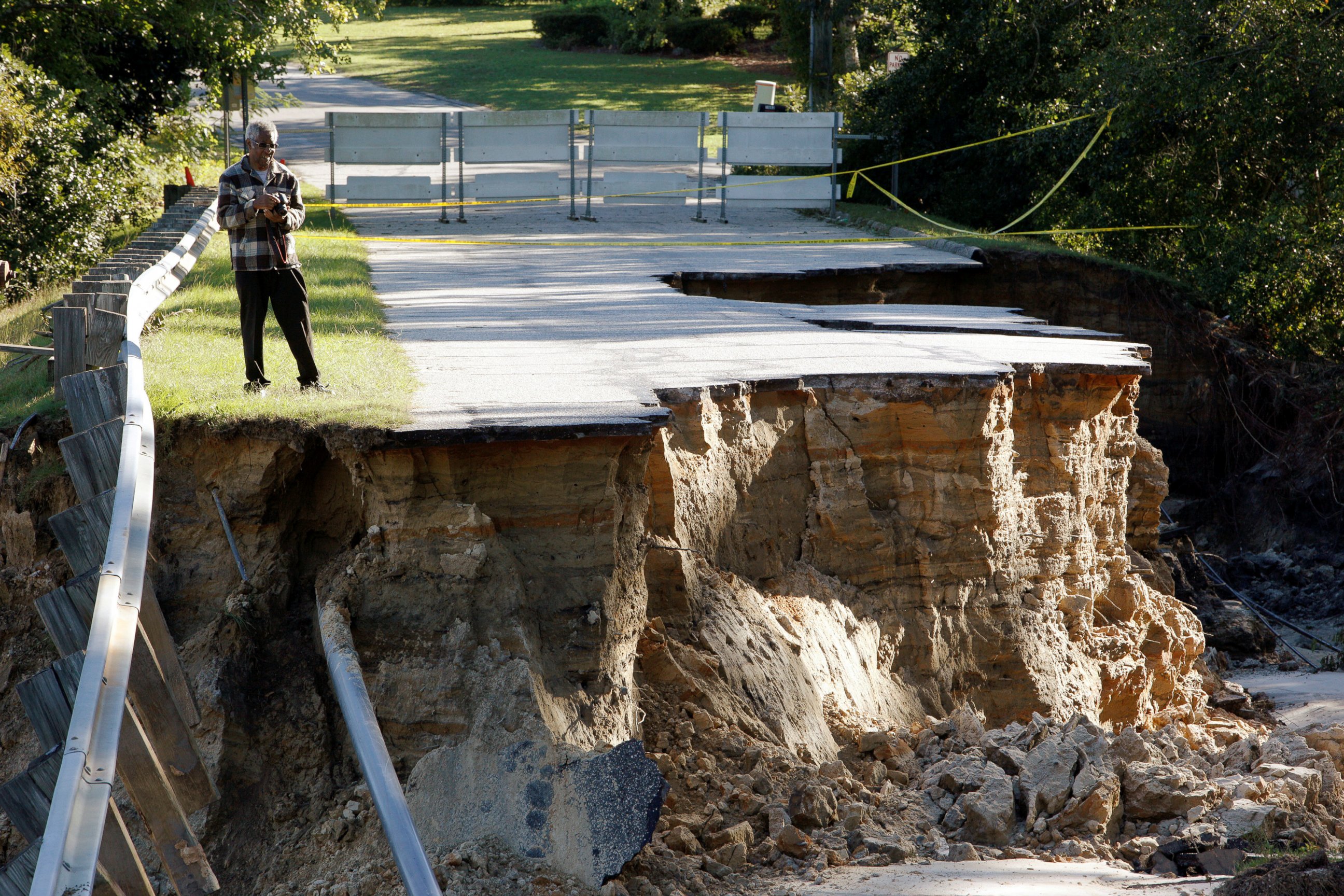 PHOTO: A resident surveys the scene of a washed out road after Hurricane Matthew struck the state, in Fayetteville, North Carolina, Oct. 10, 2016.   