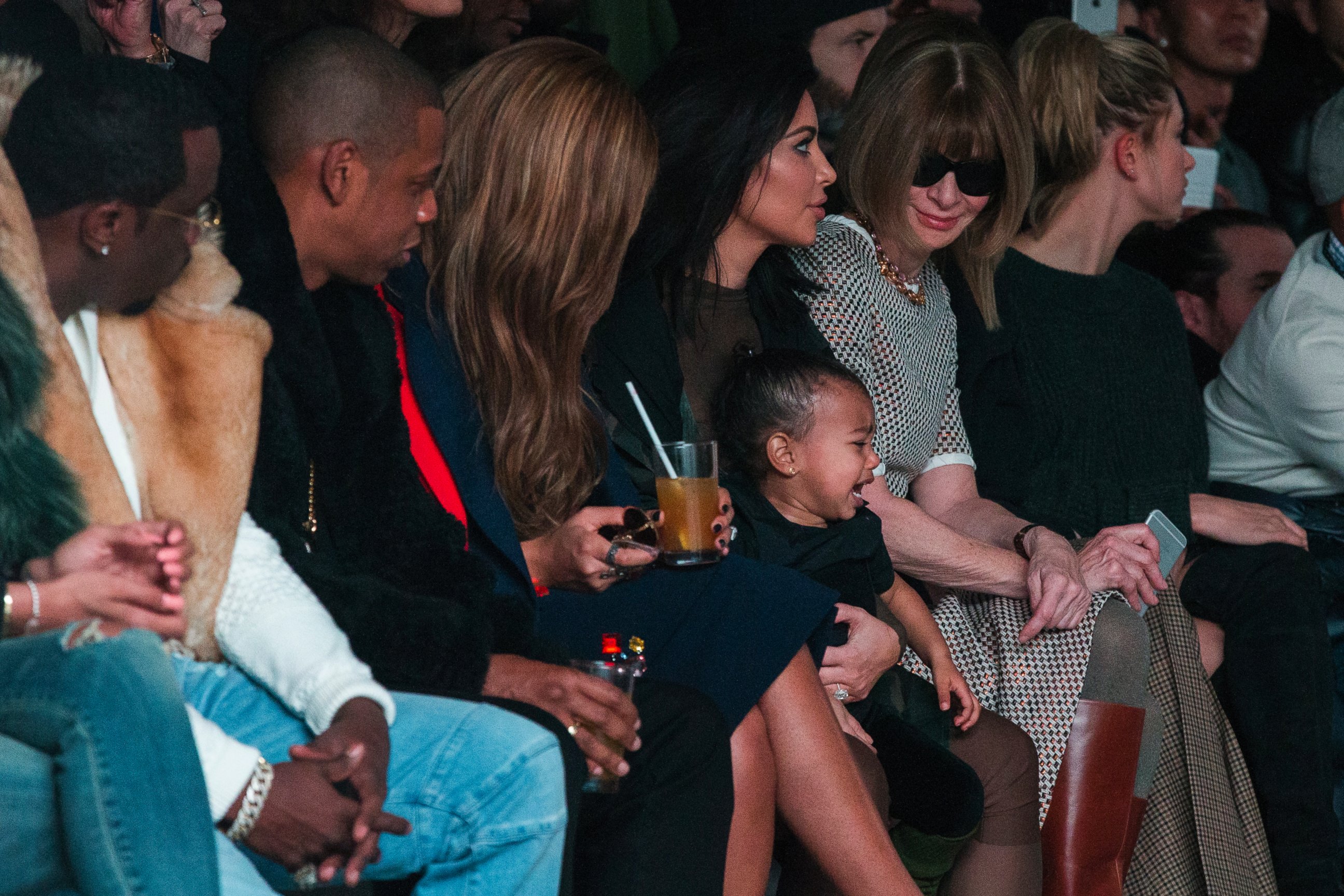 PHOTO: Kim Kardashian attempts to calm her daughter, North, while sitting next to Sean Combs  Jay-Z  Beyonce  and Anna Wintour as they watch a presentation of Kanye West's Fall/Winter 2015 partnership with Adidas at New York Fashion Week, Feb 12, 2015.