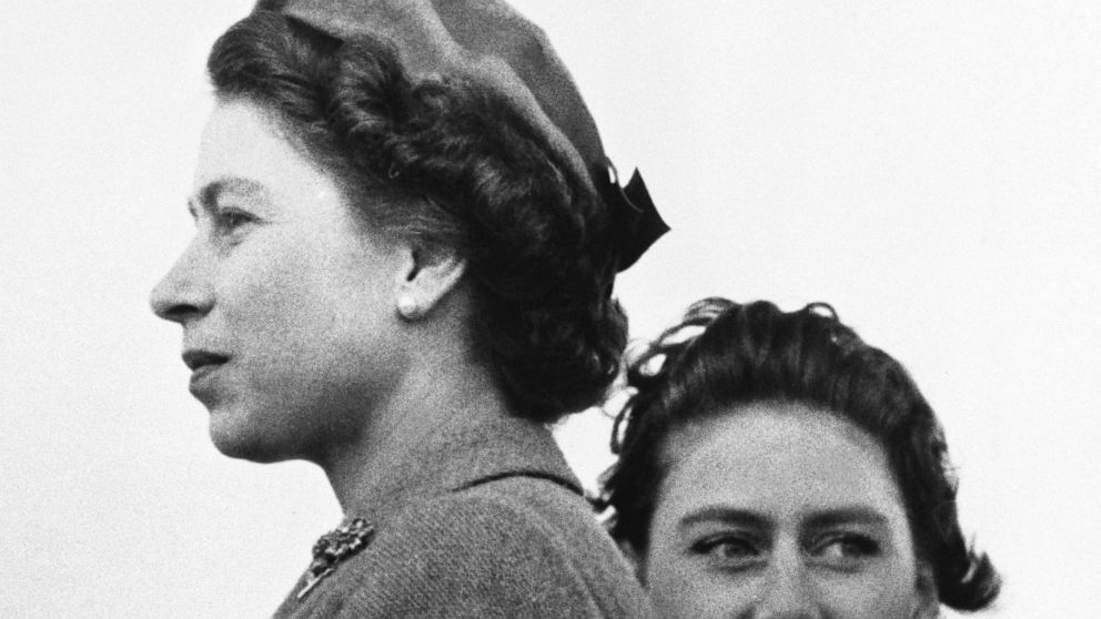 FILE - In this April 30, 1955 file photo, Britain's Queen Elizabeth II and Princess Margaret, right, look in different directions, as they attend the West Norfolk hunt point-to-point races, in Sporle, England. Queen Elizabeth II, Britain’s longest-re