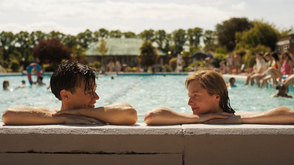 This image released by Amazon shows Harry Styles, left, and Emma Corrin in a scene from "My Policeman." (Amazon via AP)