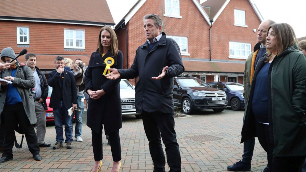 In this photo dated Saturday, Dec. 7, 2019, British actor Hugh Grant poses for a photo with Liberal Democrats Party election candidate Monica Harding, during an election campaign visit in the Esher and Walton constituency, Walton-on-Thames, England. 