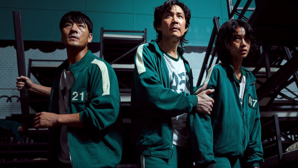 This undated photo released by Netflix shows South Korean cast members, from left, Park Hae-soo, Lee Jung-jae and Jung Ho-yeon in a scene from "Squid Game." Squid Game, a globally popular South Korea-produced Netflix show that depicts hundreds of fin