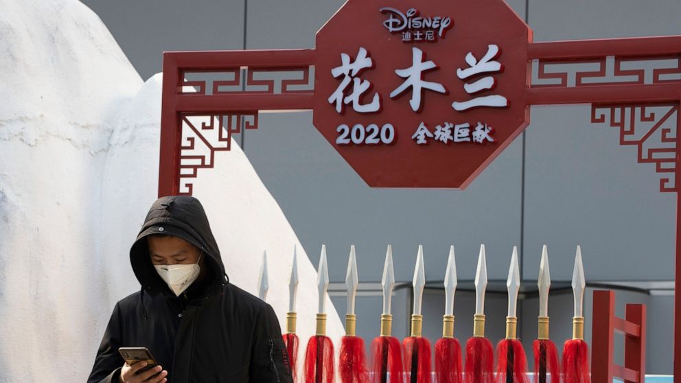 A man stands in a set promoting the Disney movie Mulan in Beijing on Wednesday, Feb. 19, 2020. Disney is under fire for filming part of its live-action reboot “Mulan” in Xinjiang, the region in China where the government has been accused of human rig