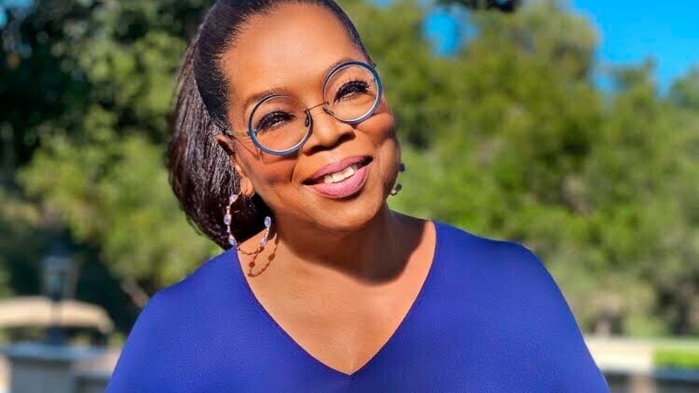 Oprah Winfrey poses for a photo with an iPad, displaying the cover image for her Oprah's Book Club selection "The Sweetness of Water" by Nathan Harris. The 29-year-old Harris, whose book comes out Tuesday, has said he wanted to show what it was like 